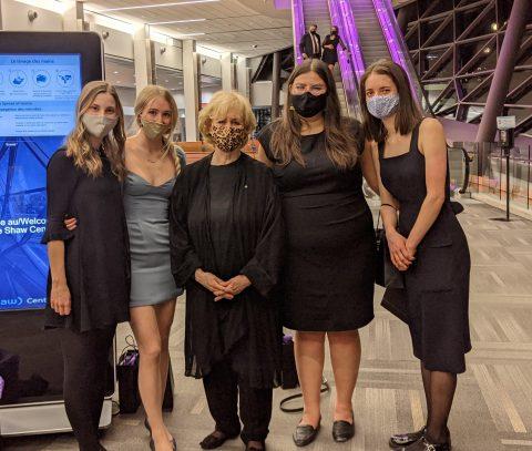 Quatre stagiaires avec la première femme première ministre du Canada, Kim Campbell, portant un masque lors d'un événement.