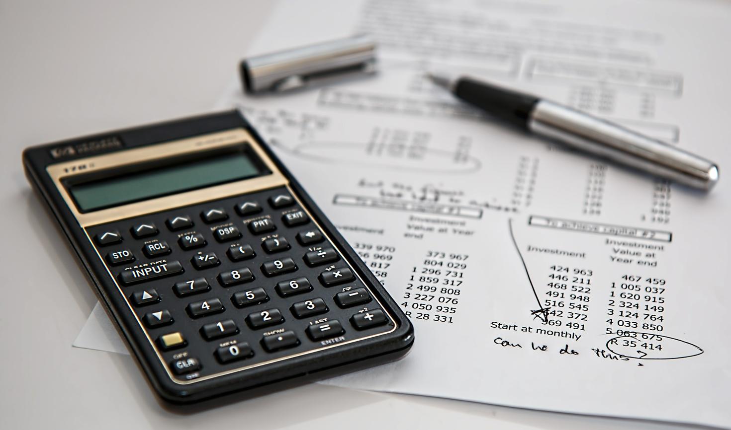 calculator, pen and circled invoice 