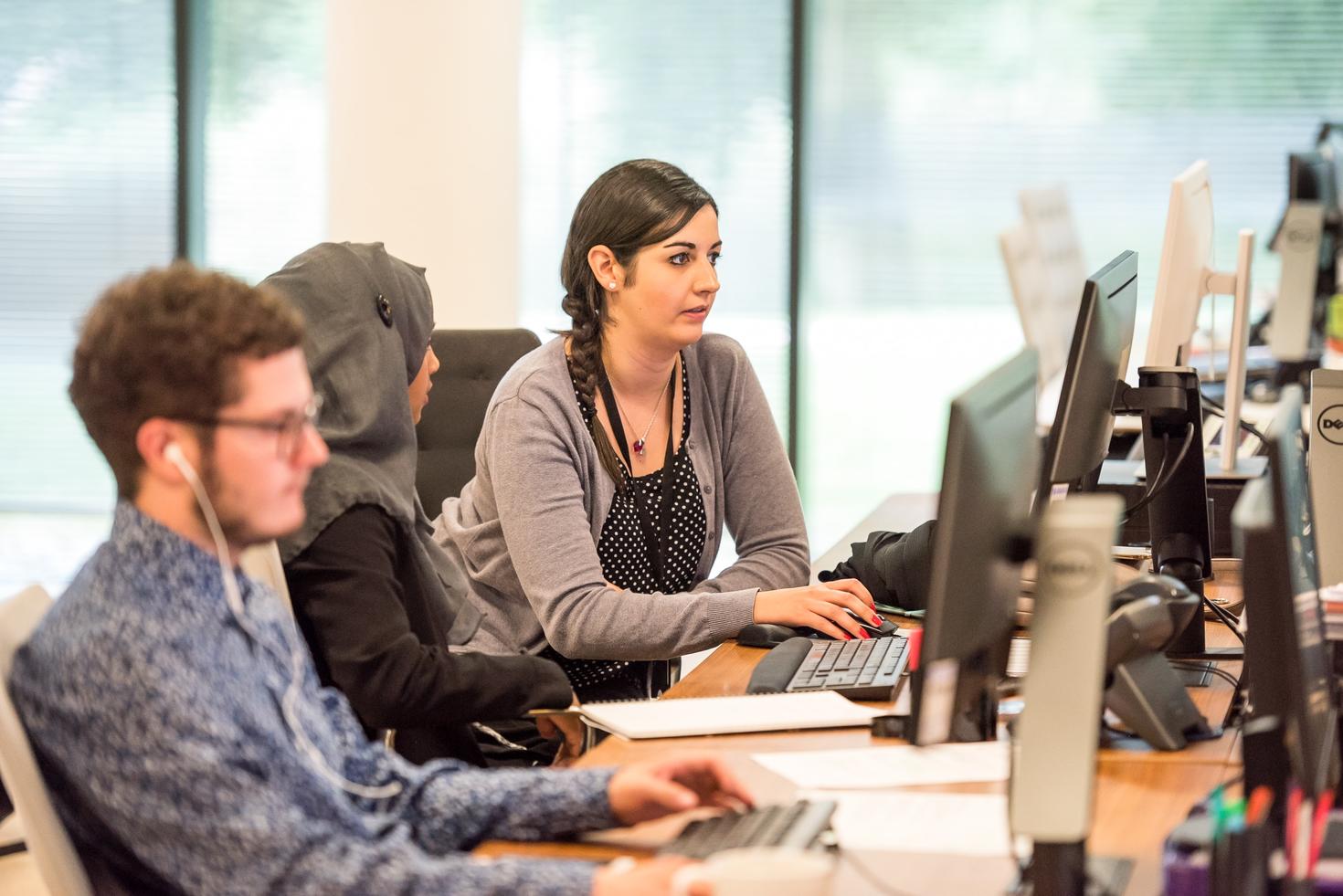 Several individuals work in a computer lab