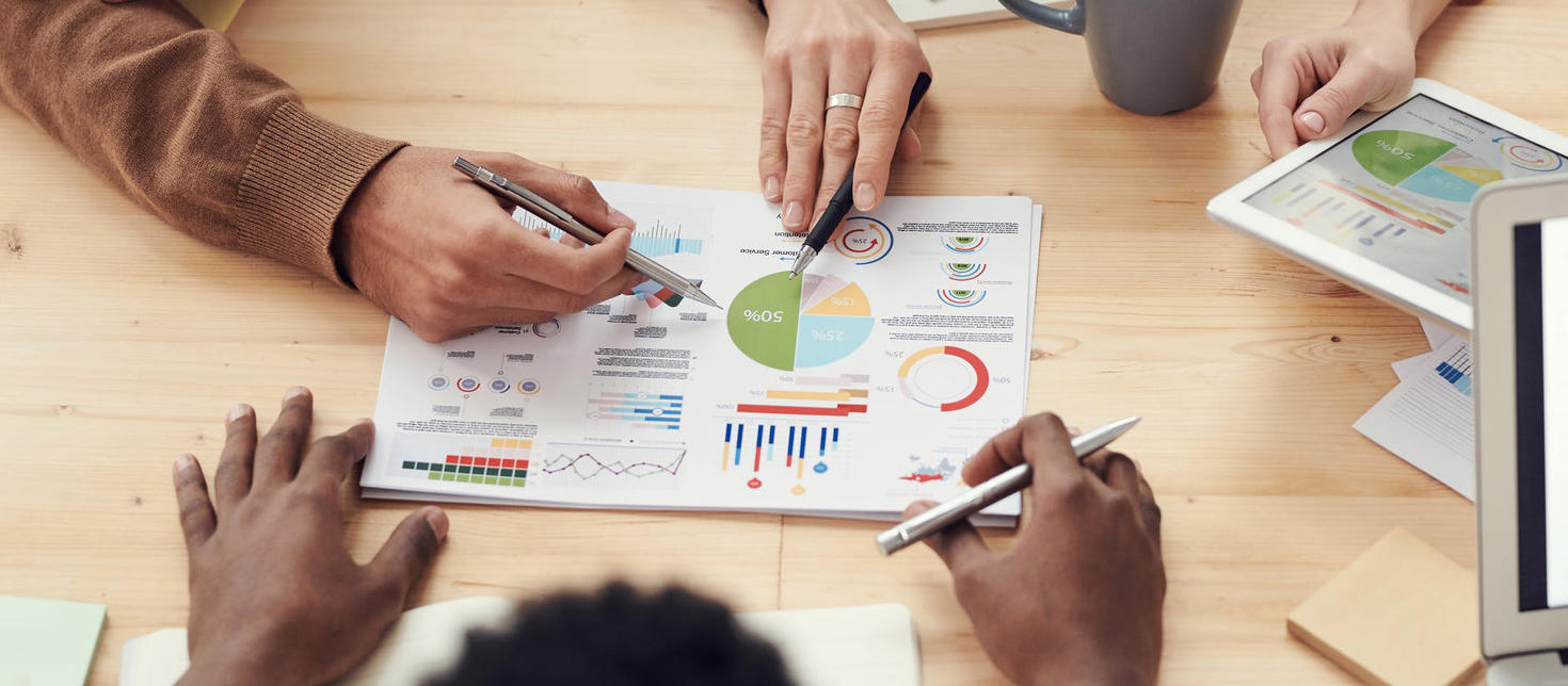 Des mains qui travaillent sur un plan d'action autour d'une table