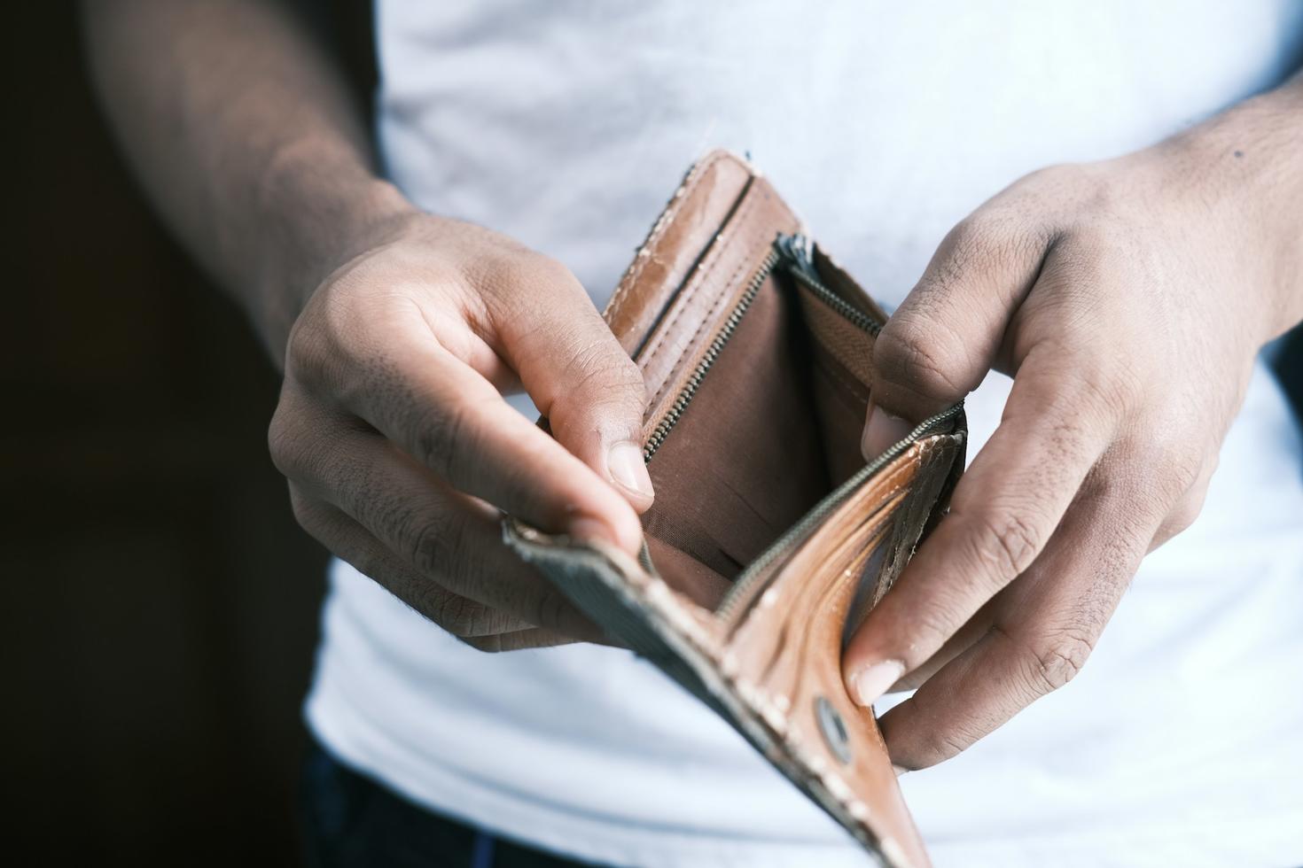 Un homme ouvre son portefeuille et découvre qu'il est vide