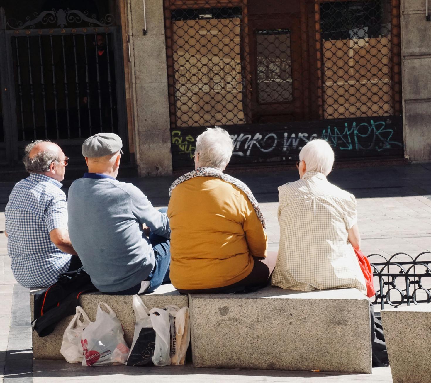Four elderly people sitting on a bench