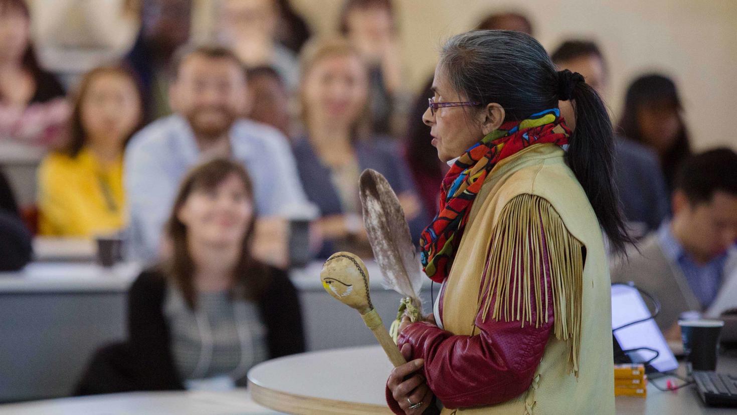 An Indigenous woman speaking in front of a class
