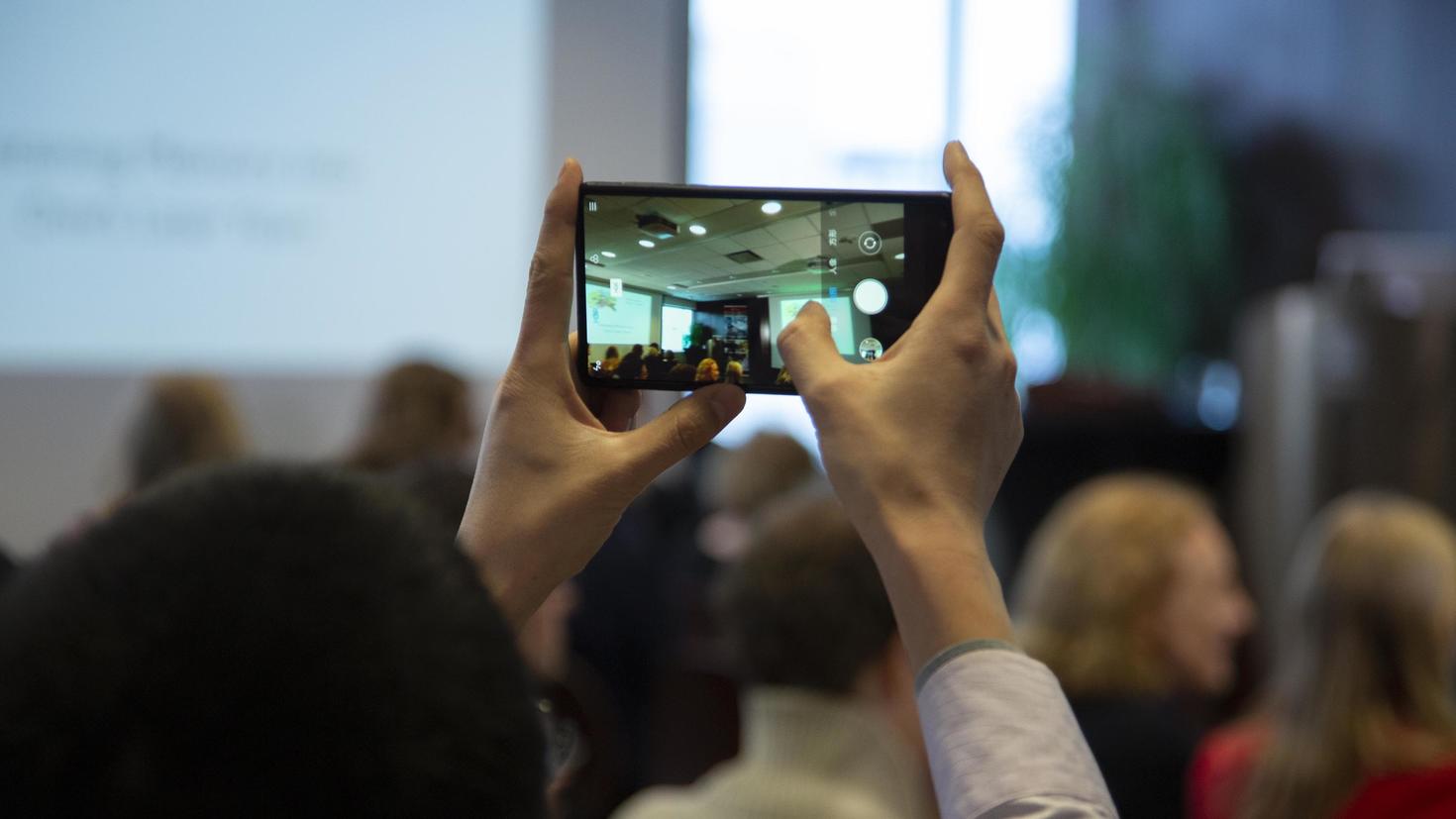 Hands holding a smart phone to take a photo