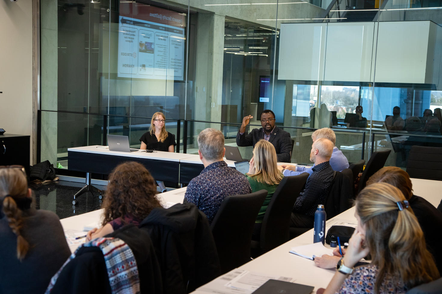 Didier and Emma presenting to their colleagues in a conference room