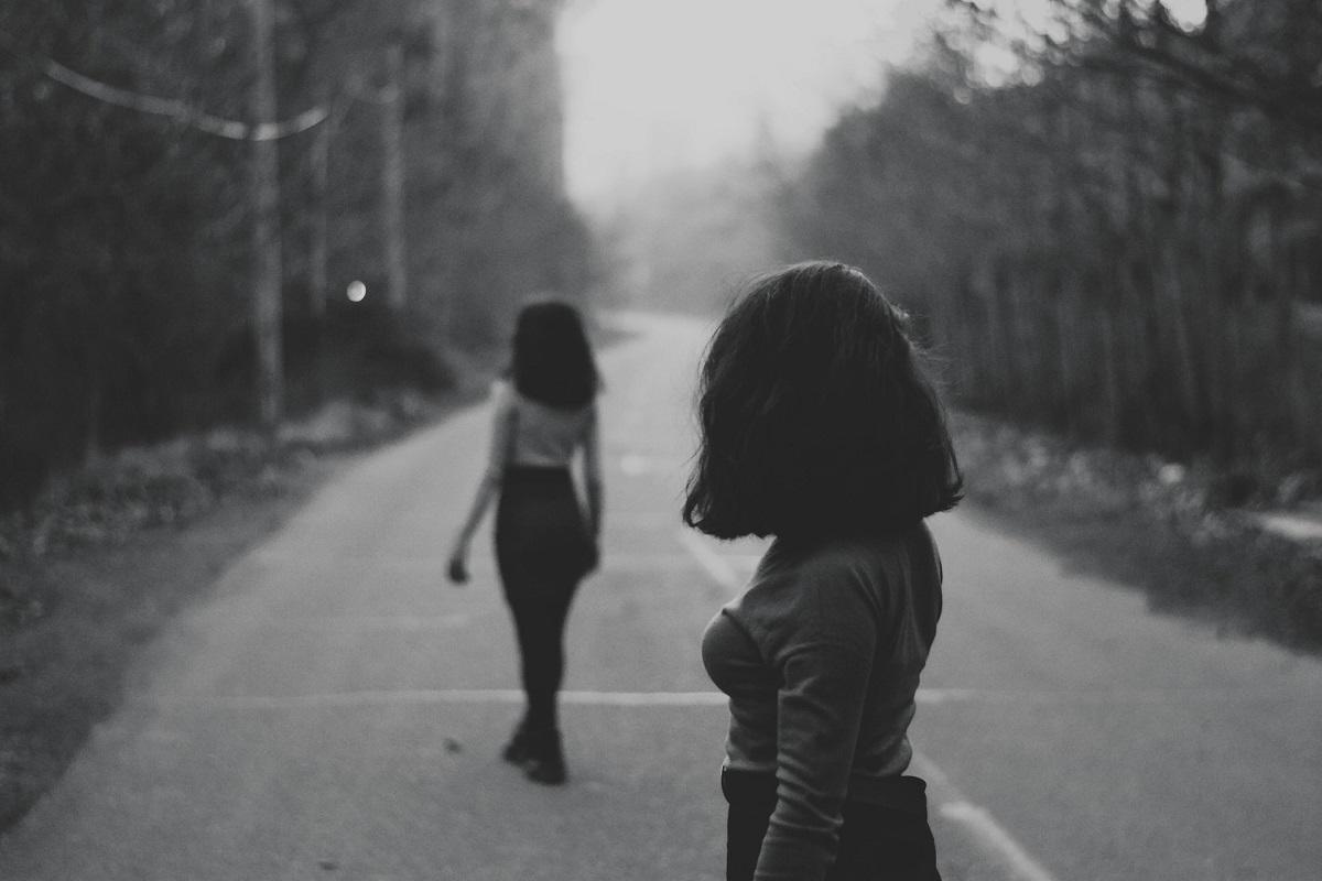 Black and white, pair of women walking away from each other
