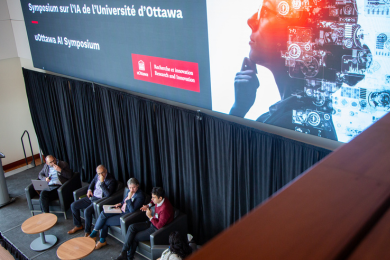 Panelists on stage at the uOttawa AI Symposium seen from above.