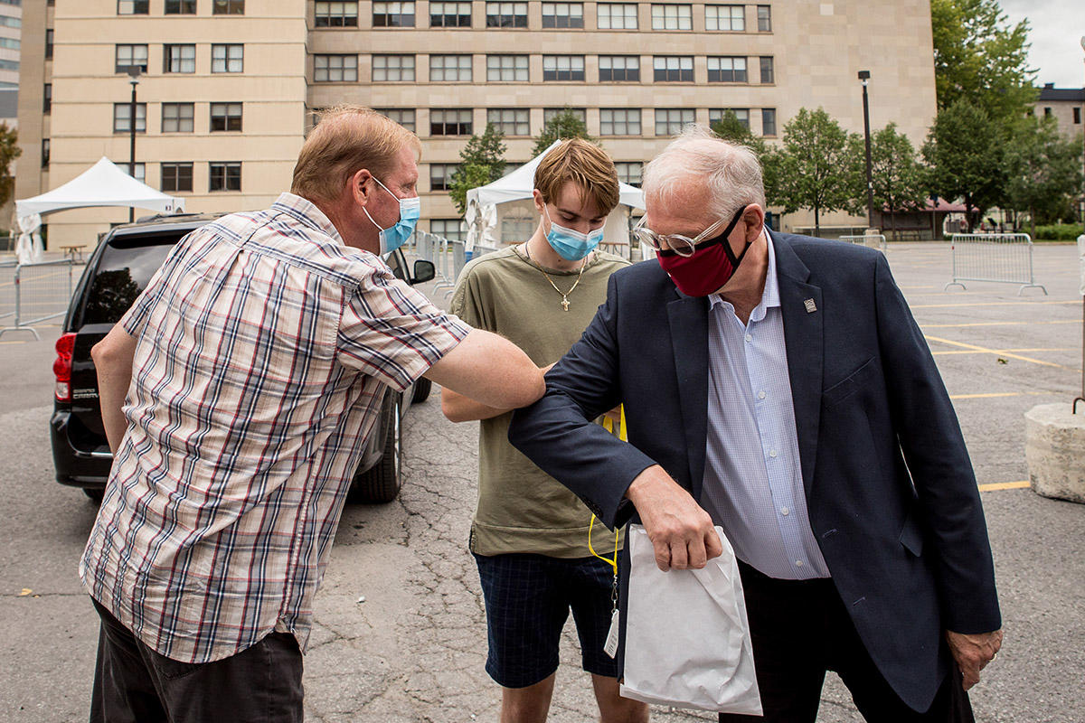 President Fremont greets a parent by touching elbows