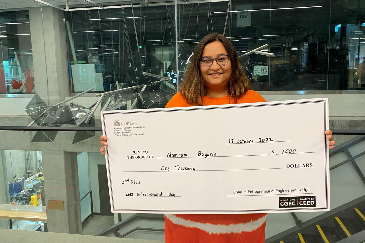 Engineering student Namrata Bagaria holds a $1000 check.