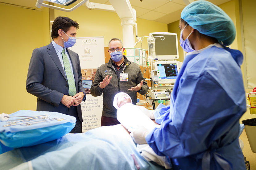 Le Dr Glenn Posner fait visiter au premier ministre Justin Trudeau des installations de simulation d'accouchement.