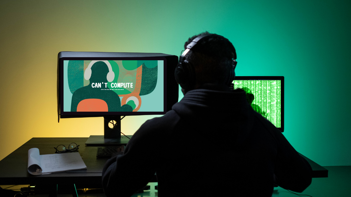 man with headphones in front of computer
