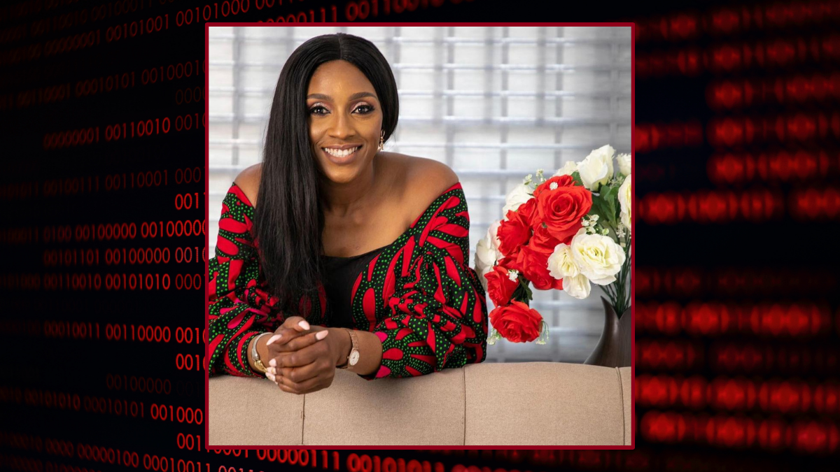 A woman leans on her elbows, she is smiling. There is a vase of roses beside her.