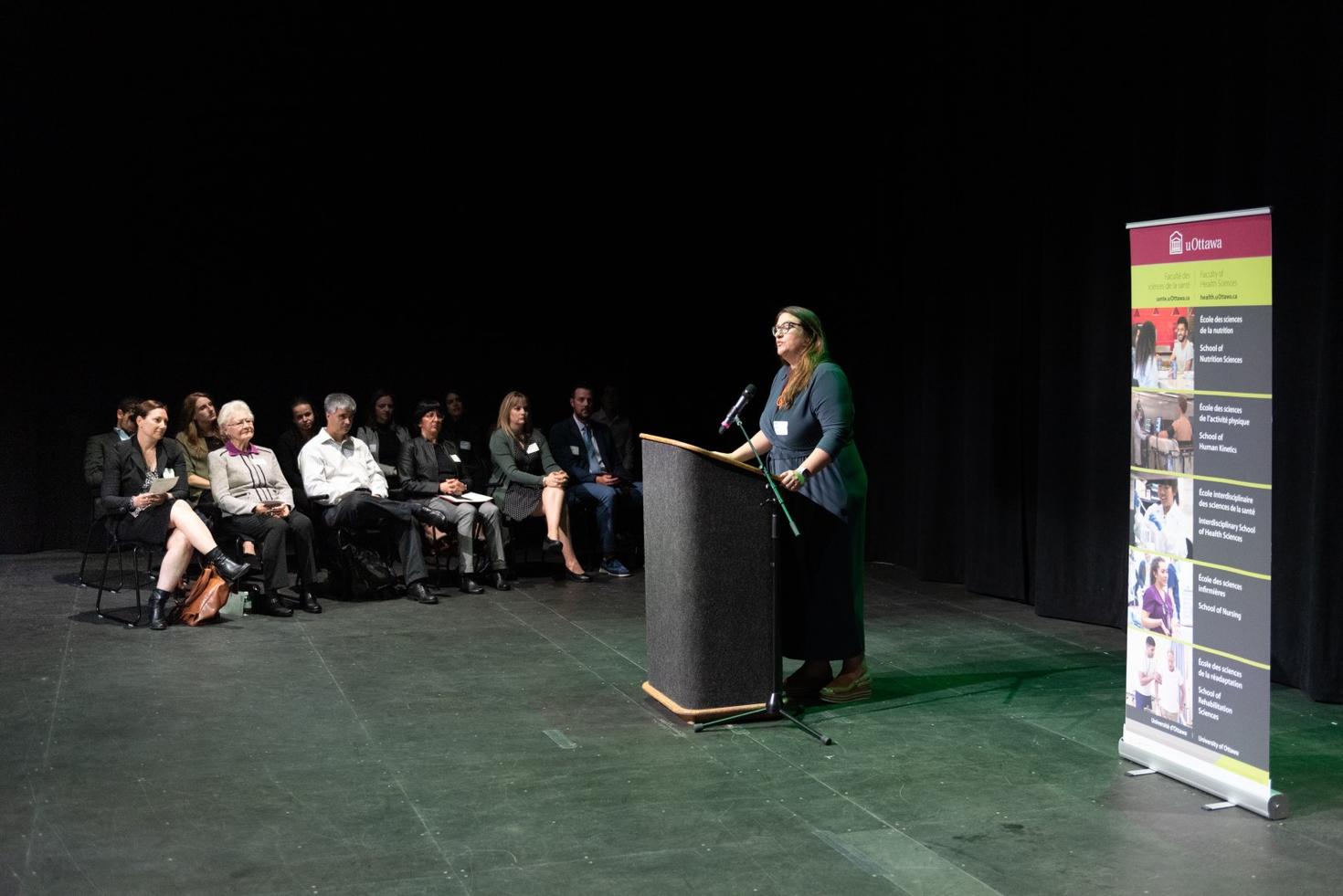Angel foster speaks in front of an audience