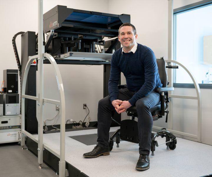Photo of Mathieu Boisgontier, he is smiling at the camera and sitting on a chair
