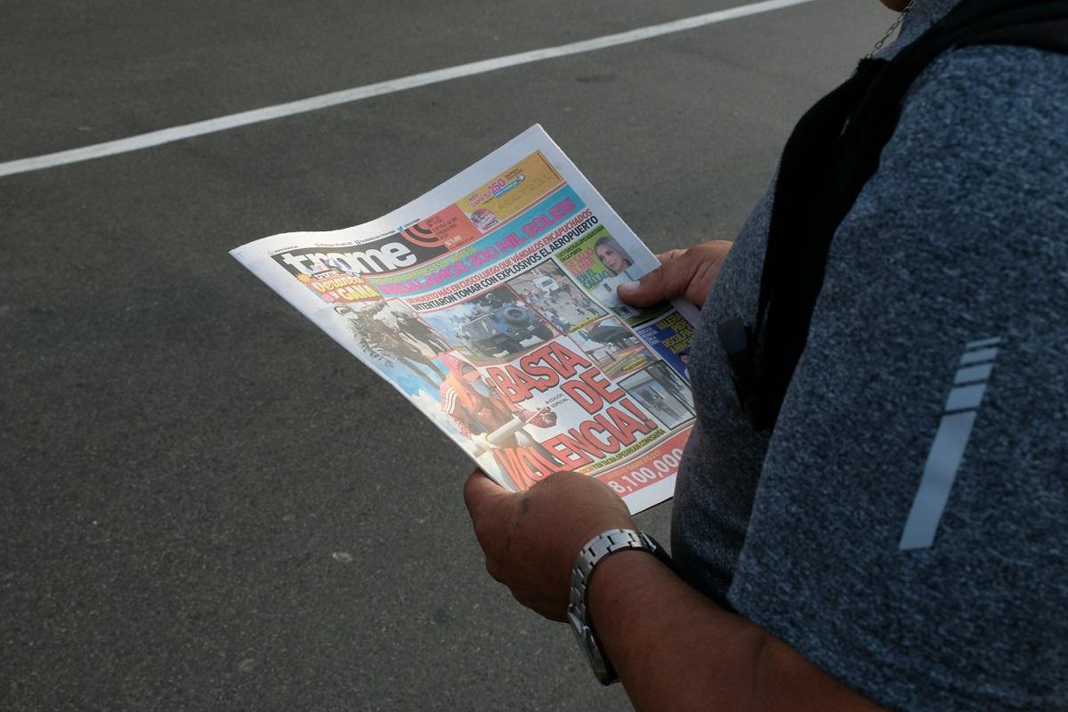 Person reading Peruvian newspaper