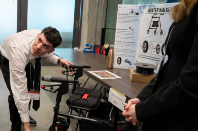 Un étudiant présente la roue rouge et noir du prototype de déambulateur hivernal conçu par son équipe lors de la Journée du design.