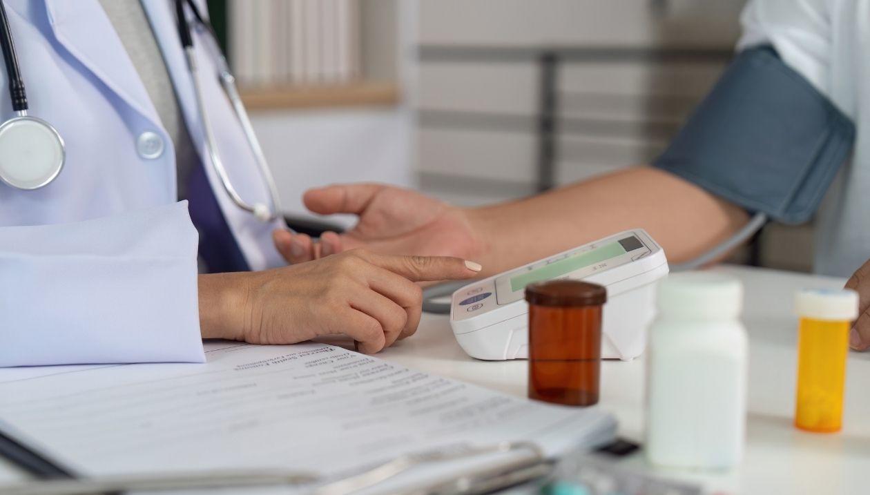 A doctor taking the blood pressure of a patient.