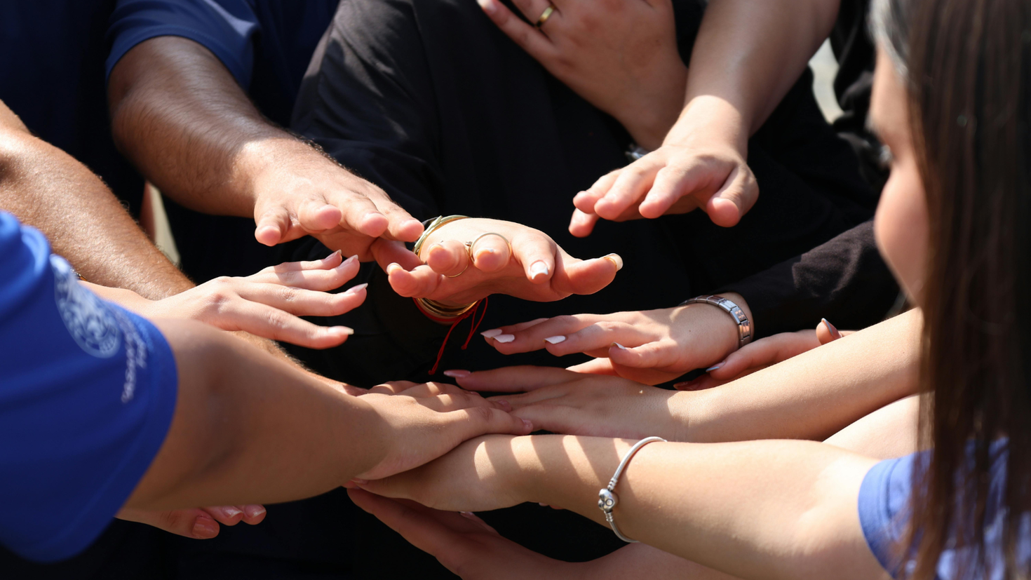 Group putting their hands together.
