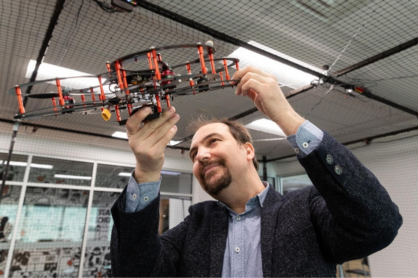 Burak Kantarci holding a drone prototype.