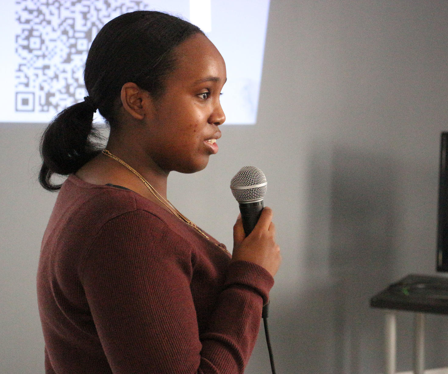 A person addressing a crowd with a microphone in their hand.
