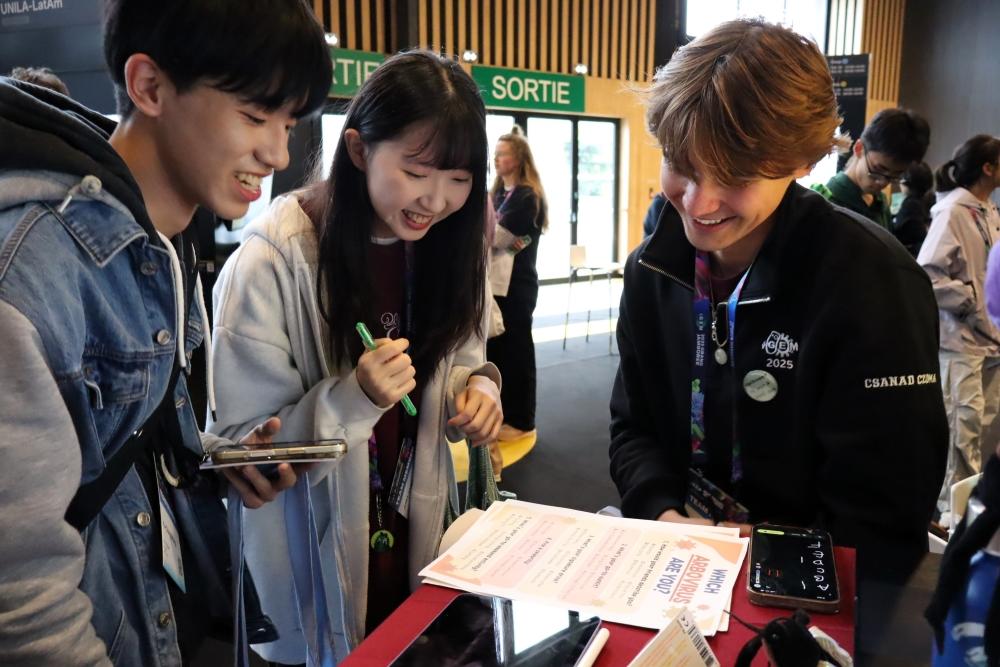 Un membre de l'équipe iGEM explique ses travaux de recherche aux participants.