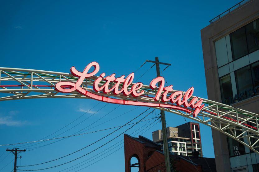Une arche métallique portant l'inscription « Little Italy » en lettres cursives.
