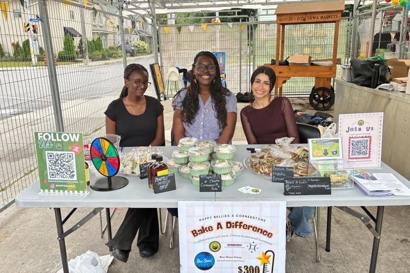 Trois étudiantes membres du club « Happy Bellies » sont assis à une table lors d'une précédente édition du Salon des clubs.