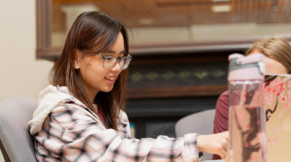 A student sits at a table, working.