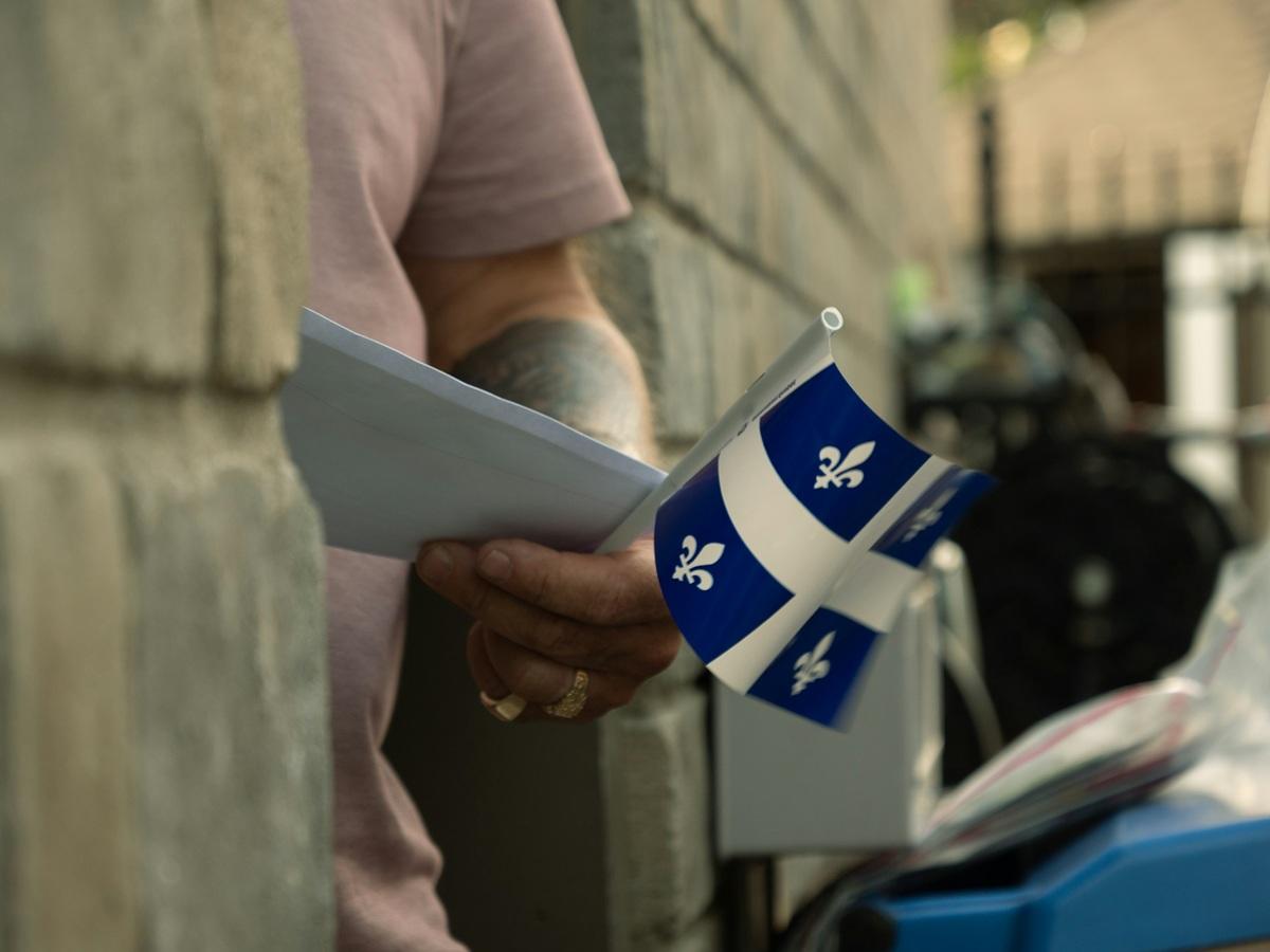 Un homme tenant un drapeau du Québec