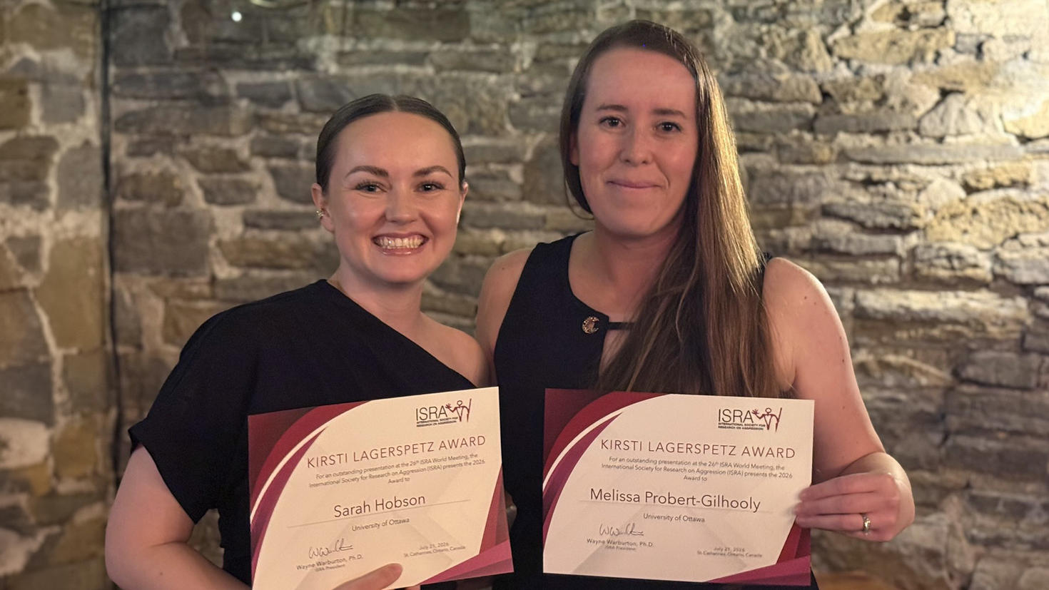 Deux personnes tenant des certificats de récompense