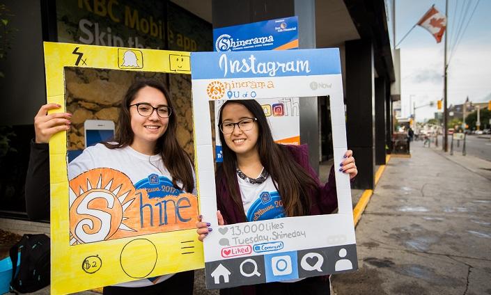 Two students “frame” themselves with cardboard.
