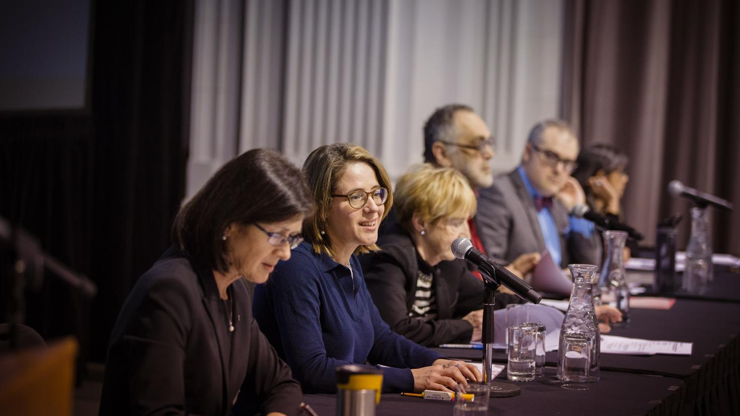 Panélistes assis derrière une table.
