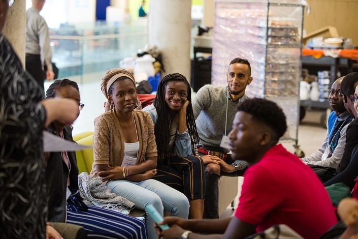 A small group of students sit together during a break in the workshop.