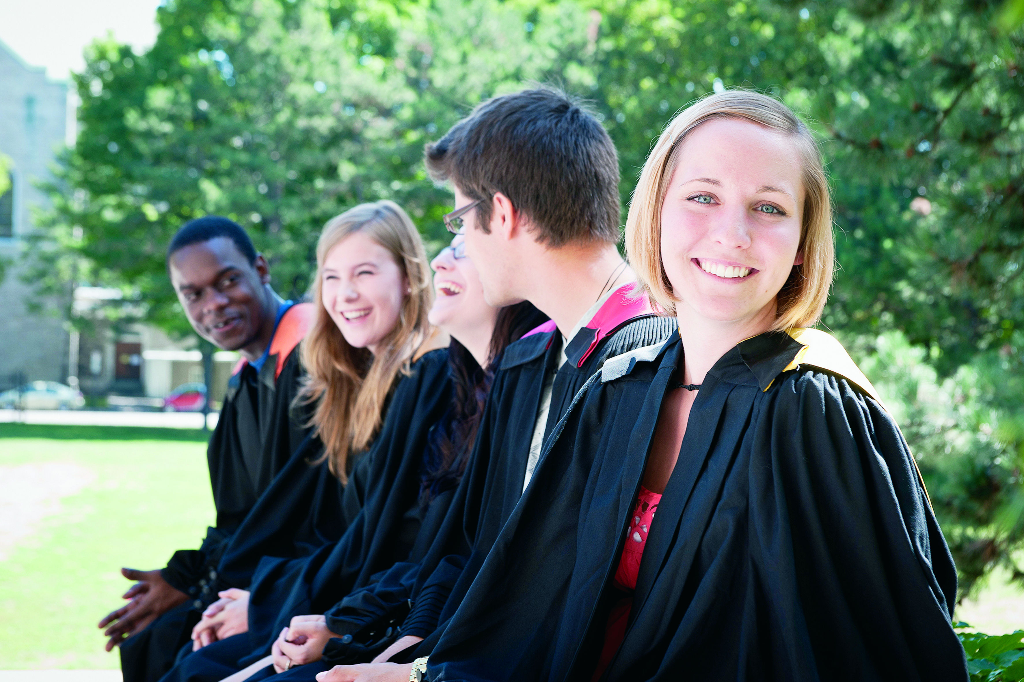 Photo d'une étudiante souriante qui vient de graduer, portant une toge