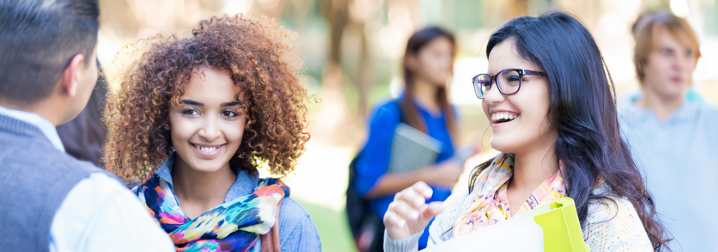 Des étudiantes qui parlent à un professeur sur le campus.