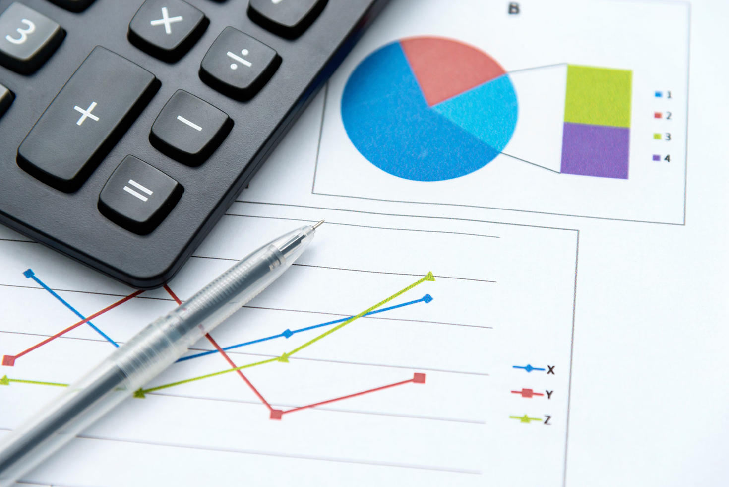 Une calculatrice, un stylo et du papier avec des graphiques