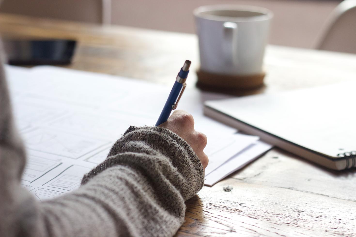 Un étudiant écrit sur une feuille de papier
