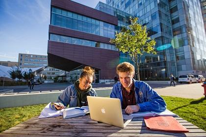 2 students studying outdoors in front of social sciences building