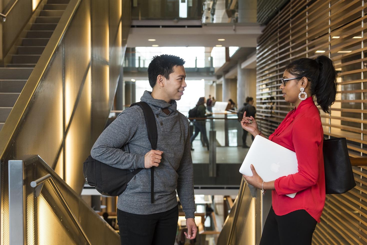 deux étudiants en conversation en haut des escaliers des sciences sociales