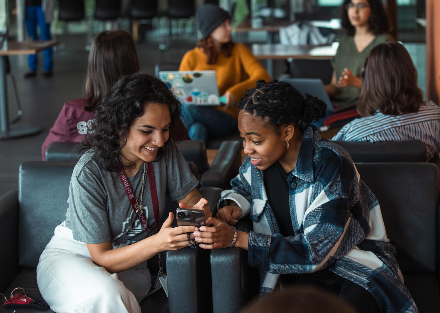 Deux étudiantes regardent un téléphone