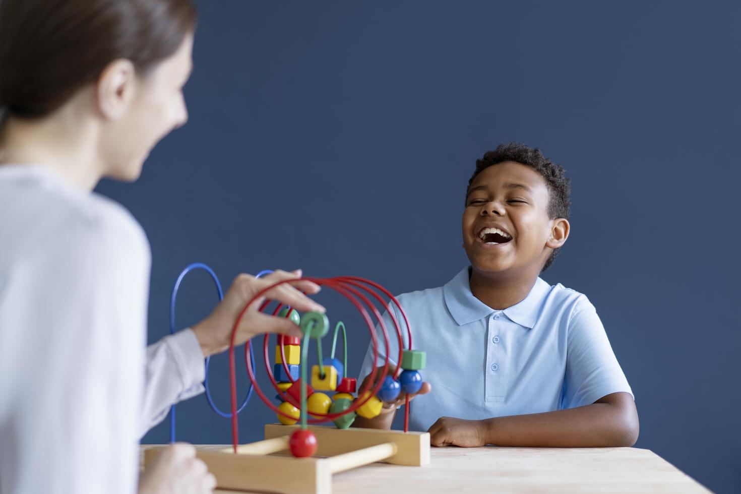 Le petit garçon faisant une séance de thérapie occupationnelle avec un psychologue