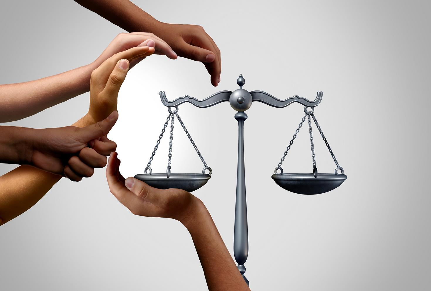 mains formant un visage autour de la balance de la justice