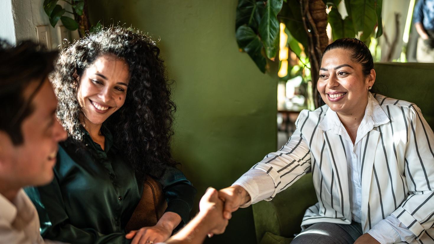couple souriant saluant une travailleuse sociale