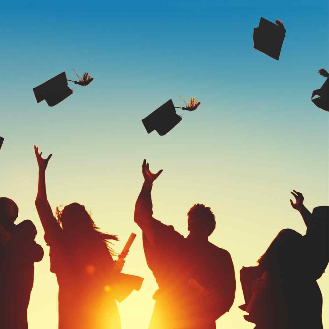 des étudiants qui lancent en l'air leur chapeau de fin d'études 