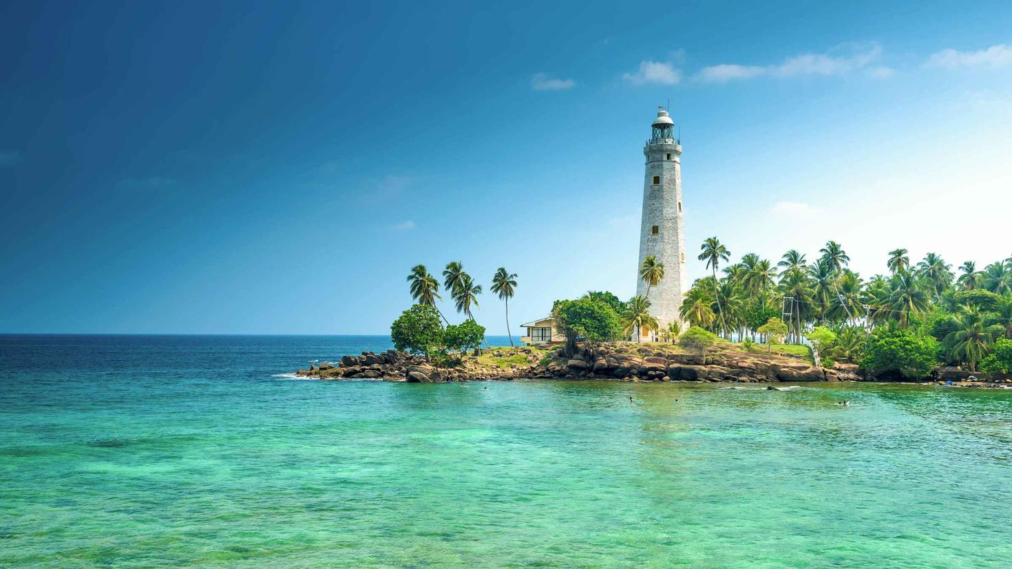 Eau bleue claire au premier plan et petite île à l'arrière-plan