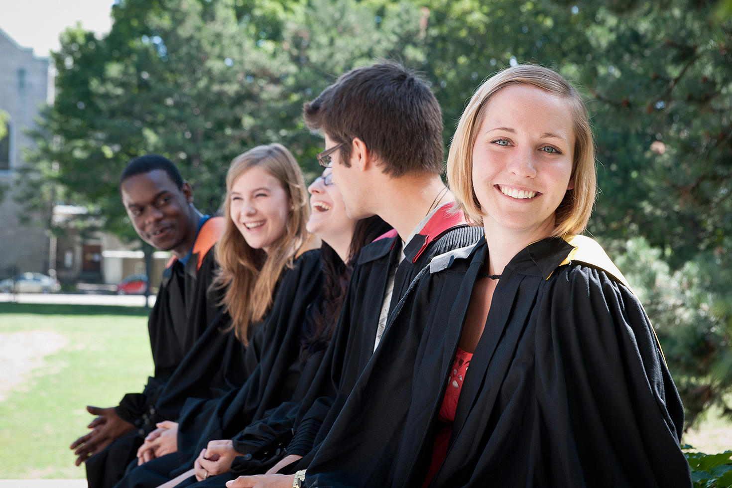 Étudiante souriante habillée avec une toge de graduation.
