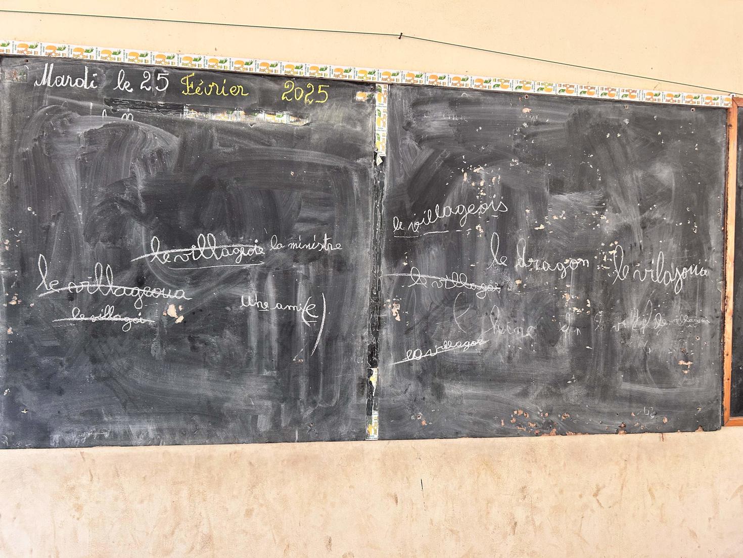 Tableau noir avec des mots écrits en lettres cursives.