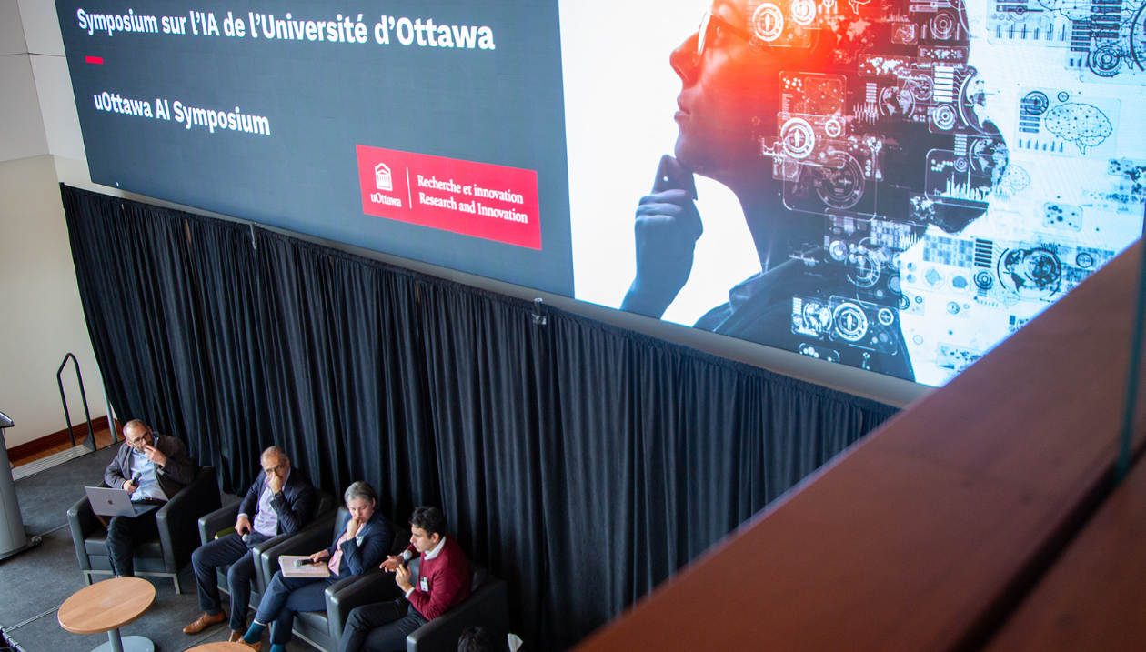 Les panélistes sur scène lors du symposium sur l'IA de l'Université d'Ottawa, vus d'en haut. 