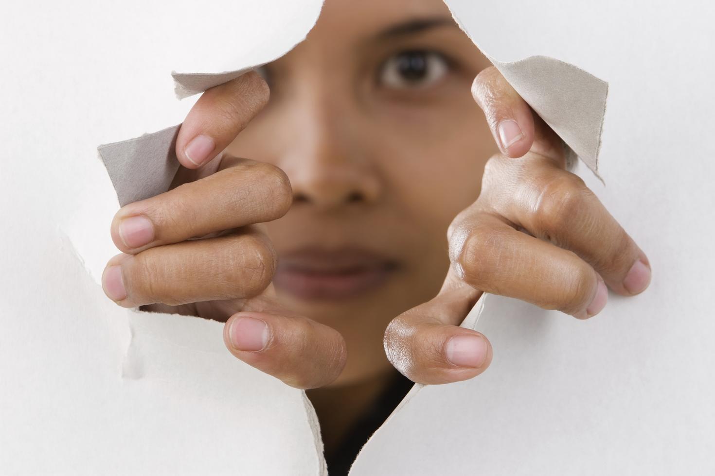 Woman looking through paper hole