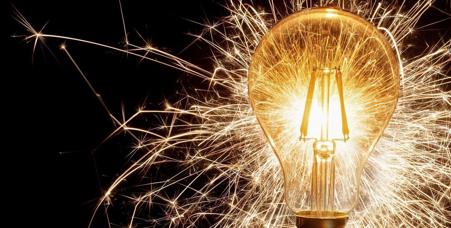 Lightbulb with sparks on black background
